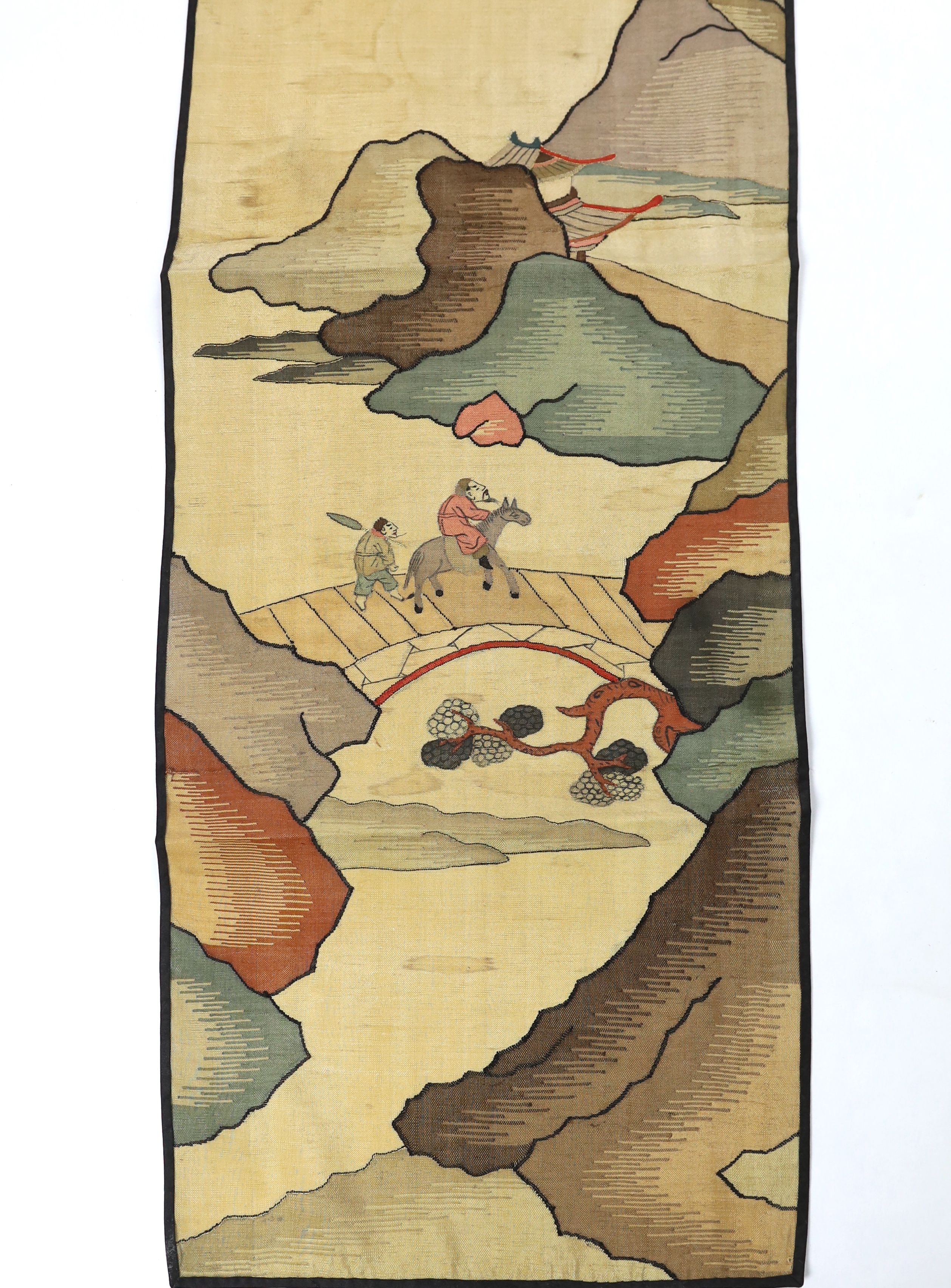 A Chinese late Qing dynasty Kesi polychrome silk hanging, depicting a figure on horseback and another walking within a mountainous landscape, together with a smaller later metallic Kesi panel of stylistic 'lishui waves',